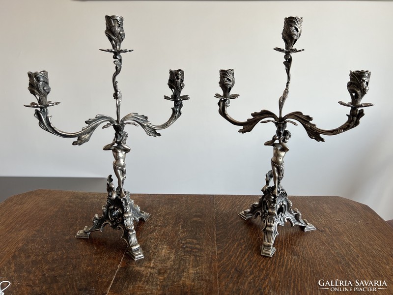 Pair of silver, figured, marked, three-pronged candlesticks