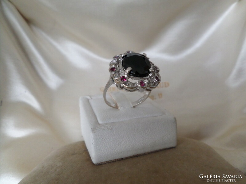White gold ring with dark blue sapphire, brilles and synthetic ruby