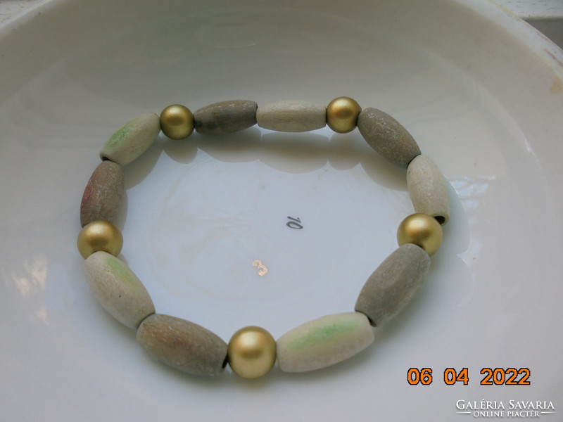 Bracelet made of beige, greenish and gold colored wooden beads