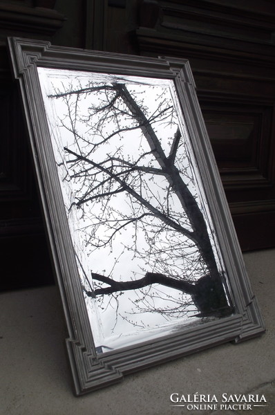 Silver-framed incised-faceted large mirror.