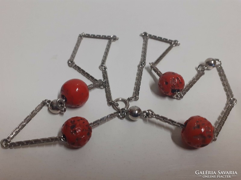 Thick stainless steel square necklace with red coral colored stones on it