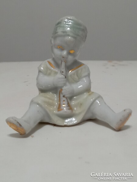 Little girl playing the flute - antique porcelain figure.