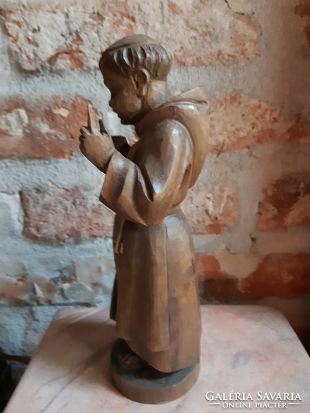 Old Spanish wooden statue of a wine-drinking monk
