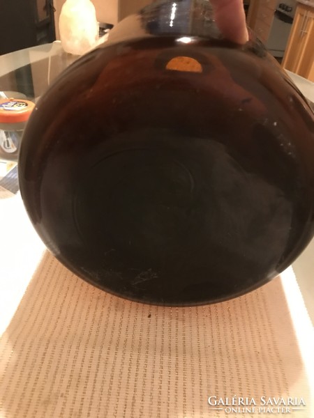 A large amber-colored glass bottle or a floor vase?