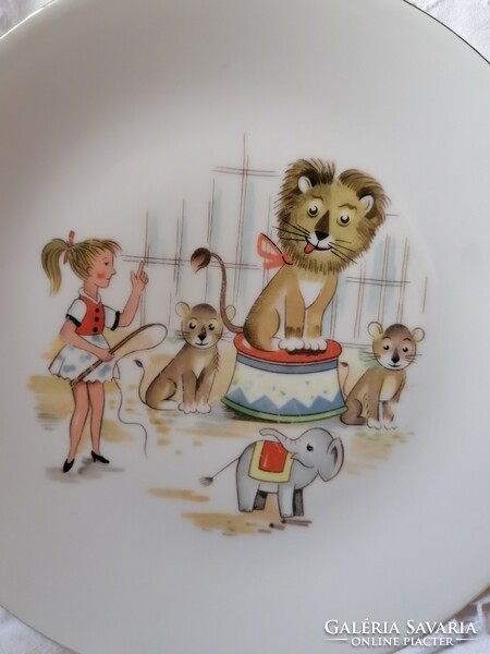 A story plate with a lion tamer, a lion, and a circus