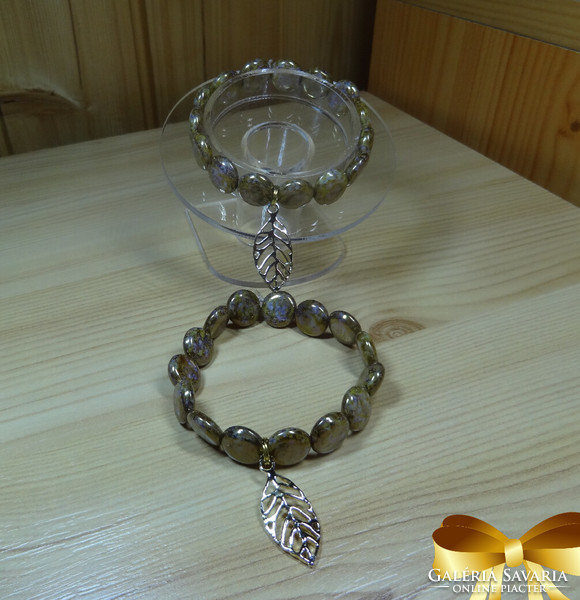 Lens-shaped bracelet made of white - gold colored pearls 14 kt. Beautiful golden leaf decoration.