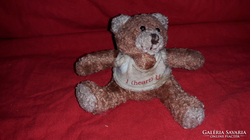 Plush sitting teddy bear offering a fairy 10 cm beanbag heart, as shown in the pictures