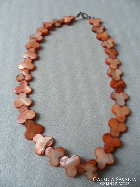A necklace or bracelet made of flat brownish mother-of-pearl pieces