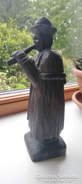 Peasant playing the flute, carved wooden figure