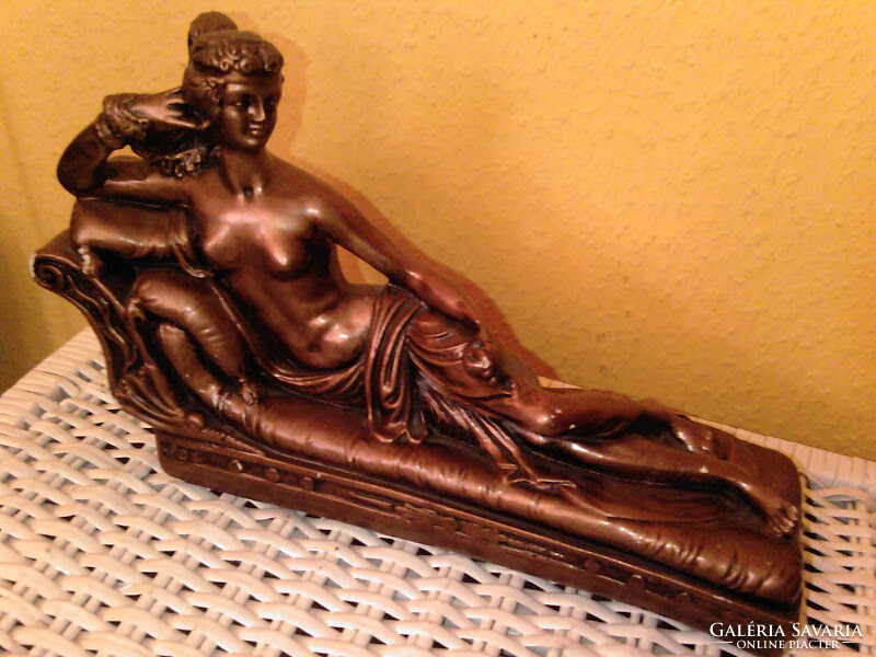 Bronzszínű szófán fekvő női akt szobor