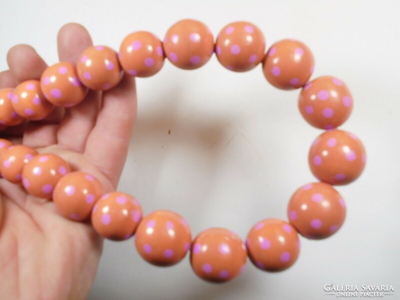 Old retro pink polka dot red necklace made of painted wooden eyes of different sizes
