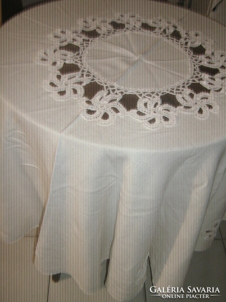 A huge round festive tablecloth in a cream color with a fabulous hand-crocheted flower insert