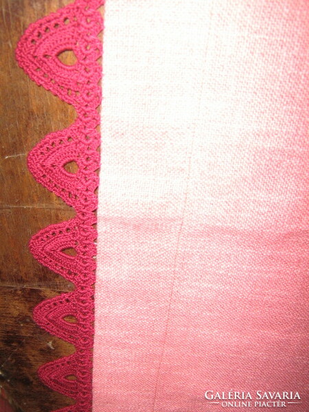 A beautiful and elegant mauve-burgundy woven tablecloth with a hand-crocheted edge and decorated with crochet