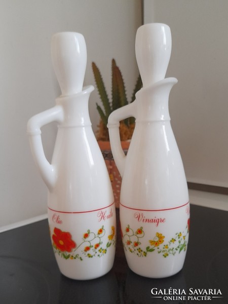 A pair of milk bottles holding oil and vinegar
