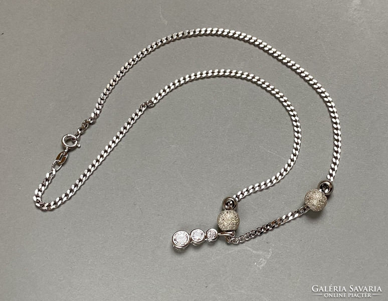 Showy silver necklace with stone pendant.
