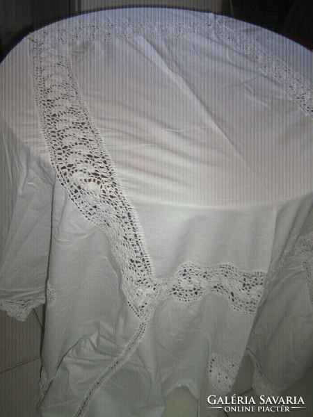 A beautiful white antique tablecloth with a hand-crocheted edge and insert