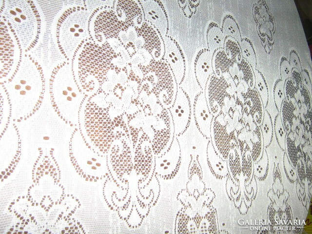 A beautiful openwork floral patterned curtain with a wavy bottom