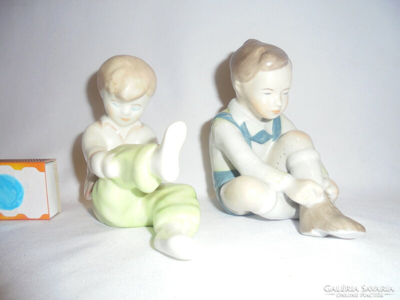 Boy and girl figure tying Aquincumi's shoes, nipp - two pieces together - the boy is wearing blue trousers