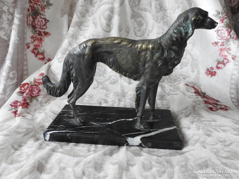 Bronze greyhound dog on a marble pedestal