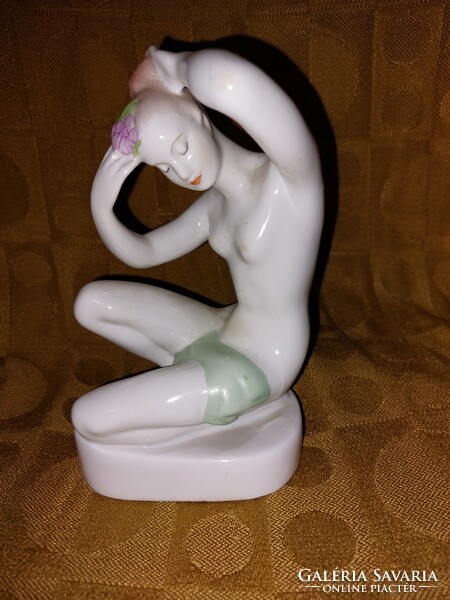 White porcelain figure of a girl combing her hair