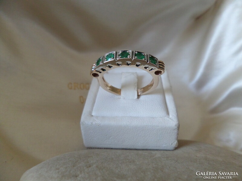 Gold row ring with emeralds
