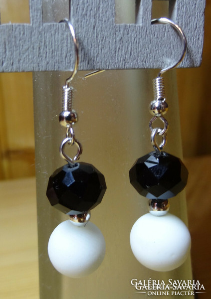 Earrings made of 8 mm pearls with black polished crystal beads and white rubber coating.