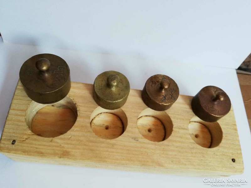 Copper scale weights in a wooden holder