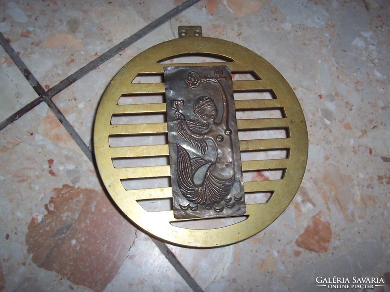 Copper circular grid cover with a mermaid image on it