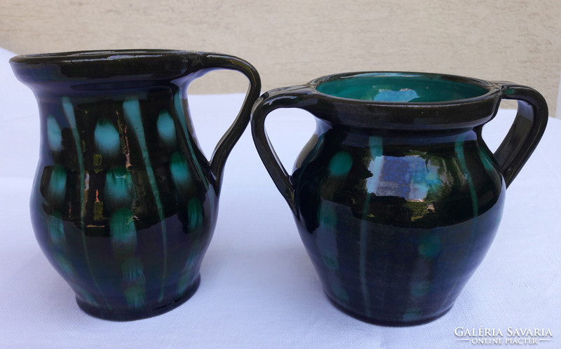 Black and turquoise patterned ceramic jugs are sold in pairs