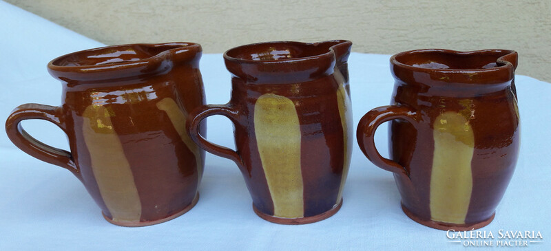Three brown-ochre striped ceramic jugs in a 