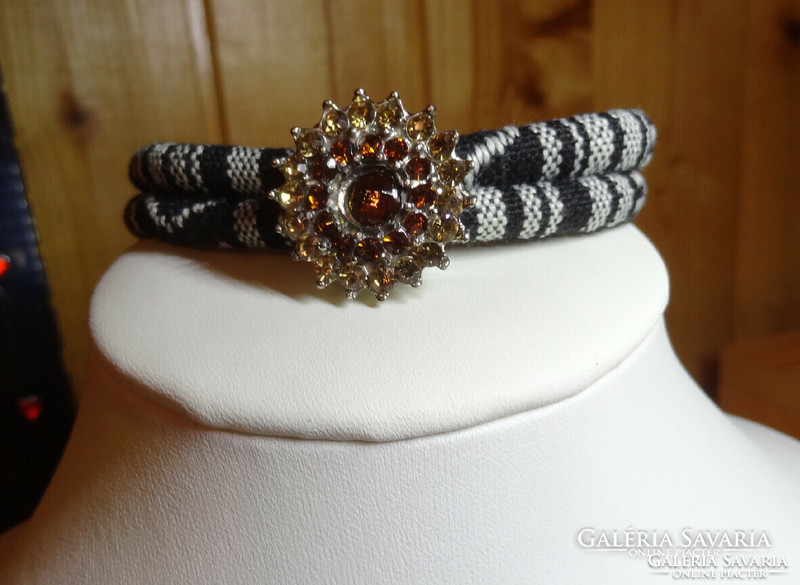Noosa bracelet made of black and white paracord cord, with matching crystal clasp.