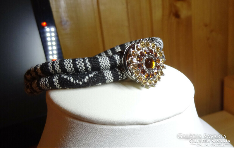 Noosa bracelet made of black and white paracord cord, with matching crystal clasp.