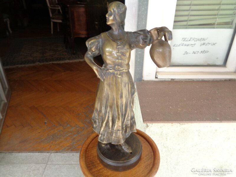 Bronze statue of a woman holding a jar