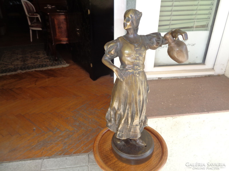 Bronze statue of a woman holding a jar