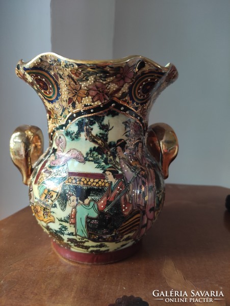 A richly gilded antique Chinese porcelain vase with decorated scenes