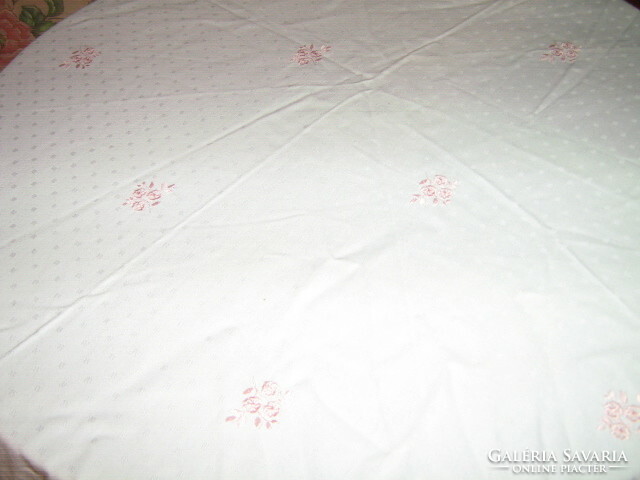 Spotted oval damask tablecloth with lacy edges embroidered with pink roses in beautiful fabric