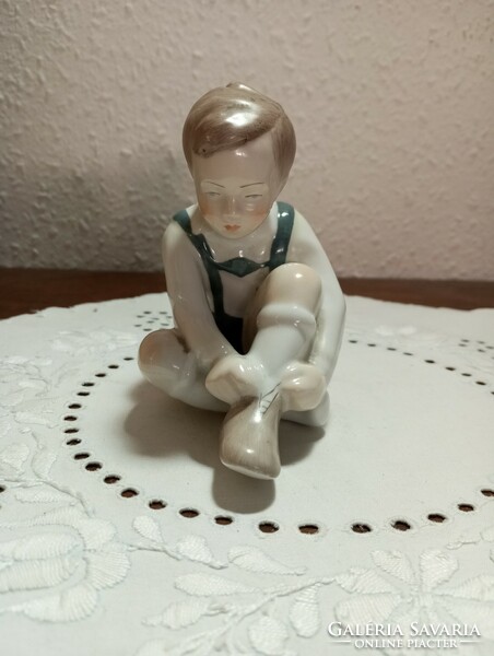Aquincum porcelain, little boy tying shoes