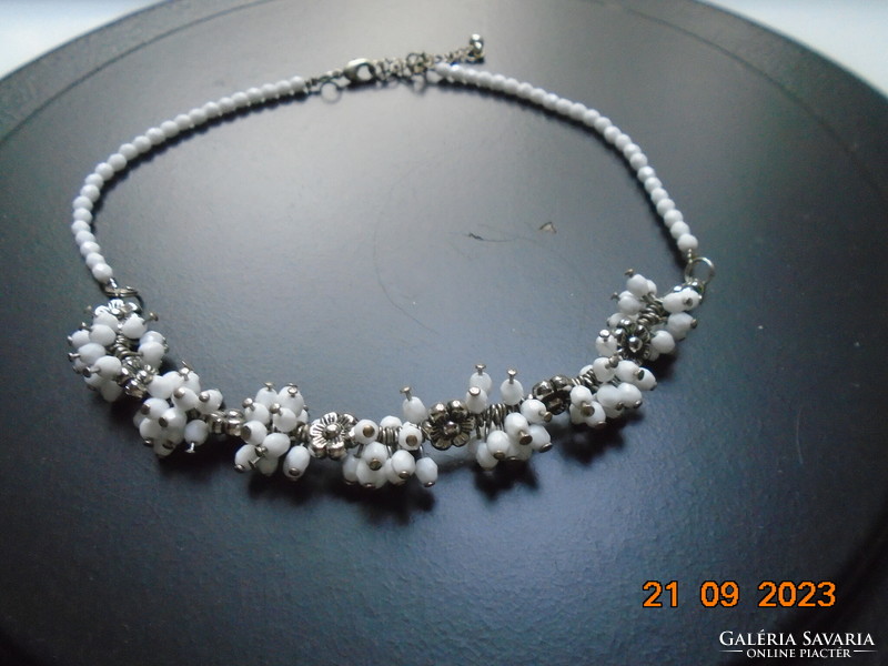 Necklaces made of polished, faceted white crystal pearl clusters and silver-plated flowers.