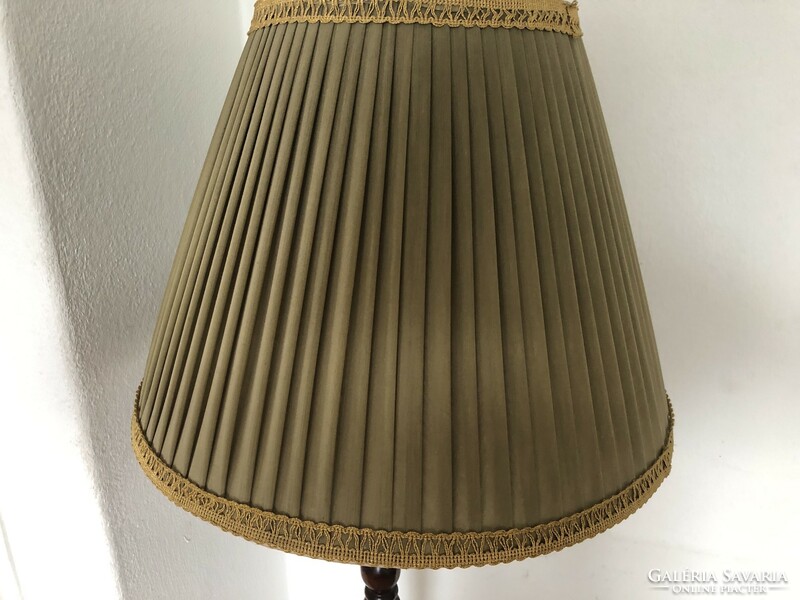 Wooden floor lamp with an olive green lampshade and gold border