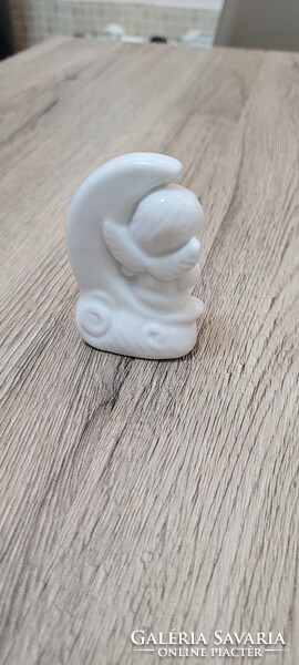 Porcelain figural sculpture of a little girl sitting on the moon.