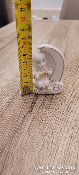 Porcelain figural sculpture of a little girl sitting on the moon.
