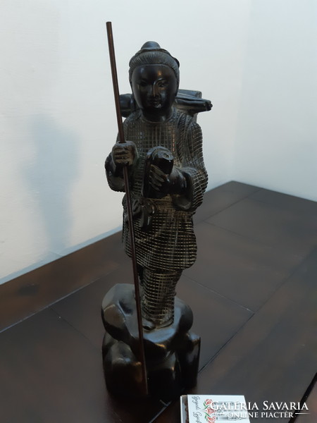 Antique solid wood statue depicting an oriental wanderer