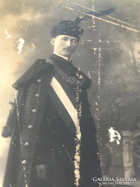 Old photo/postcard, portrait in fancy dress. The surface of the page is slightly damaged.