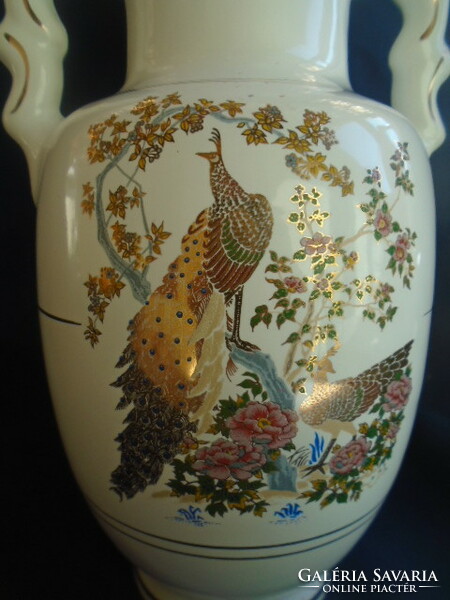 The empire-style vase decorated with peacock birds is contoured in real gold