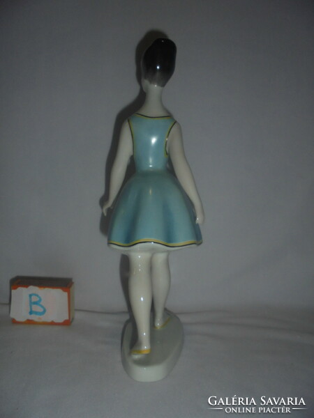 Figure of a woman walking in a blue dress from Raven House, nipp - her fingers are damaged