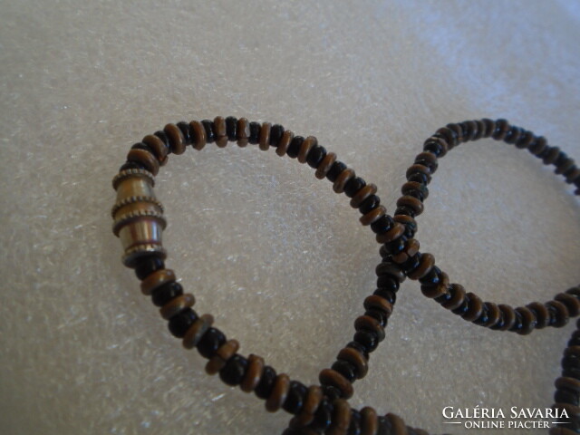 A blunt head carved from ebony, a brutally serious necklace, a very massive chain weighing 30 grams
