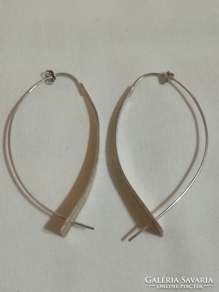 Large silver earrings with multiple markings.
