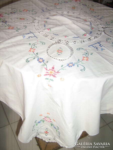 Beautiful crochet doily and floral tablecloth embroidered with tiny cross stitches