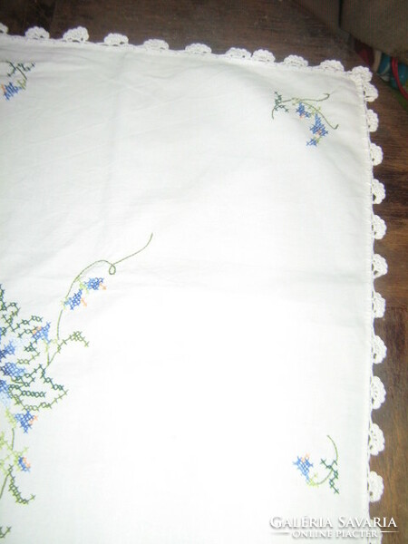 Wonderful tablecloth embroidered with blue cross-stitches with floral pattern inserts