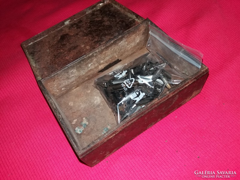 Antique tin box with old contents on a large pile of pen nibs along with pictures